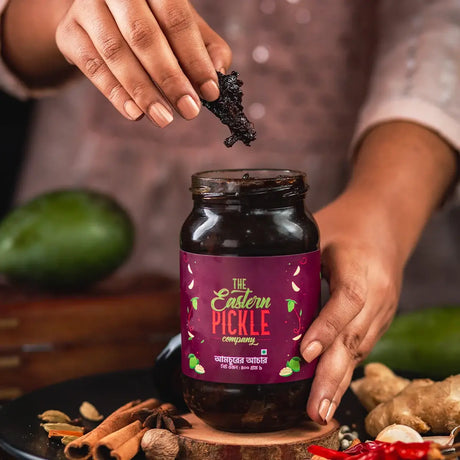 Someone is picking Dried Mango Pickle from a big jar | Eastern Pickle