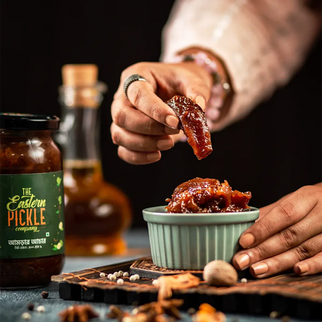 Someone is picking up Amra Pickle from a small bowl | Eastern Pickle